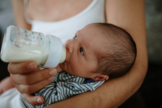 Closeup portrait of 1 month old baby eating milk from bottle