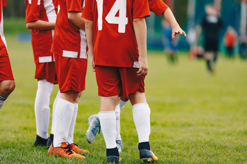 Fototapeta premium Players on bench watching amateur soccer tournament game. Group of young boys on sports field