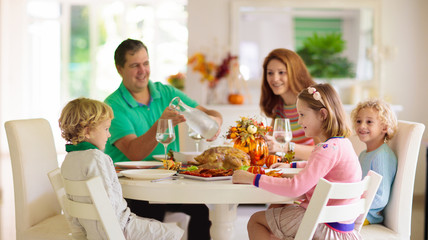 Family with kids at Thanksgiving dinner. Turkey.