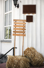 Wedding wood decoration. Copyspace on wooden board. Wooden table decorated by flowers and greenery and lounge zone. Wedding photo zone. Party zone rustic style.