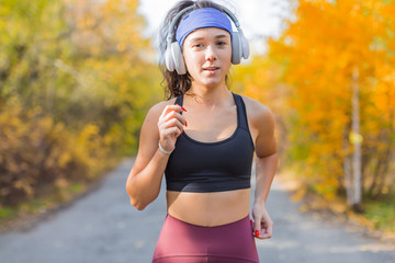 Close up photo of a running woman. Autumn outdoor portrait
