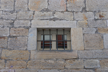 Fototapeta na wymiar Vergittertes Fenster in alter Steinmauer