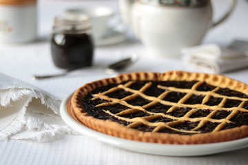 fresh pie with plum jam on white tablecloth