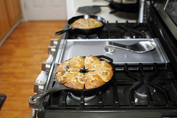 Banana nut bread with berries fresh out of the oven, baked in cast iron cookware in a home kitchen.