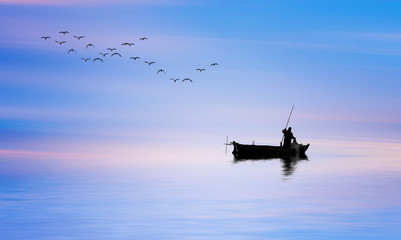 Fototapeta na wymiar pescador en su barco de madera por el mar en calma al amanecer