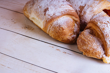 Fresh sweet pastries on white wooden background