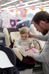 Obraz premium Dad with baby in store buying car seat.