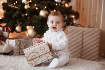 Cute kid with gift at Christmas tree.