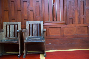 Fototapeta na wymiar Chair put on the wall of the house Thai ancient wooden.