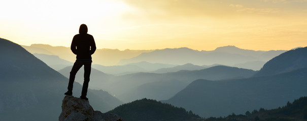 Young Man watching the Sun from the Summit