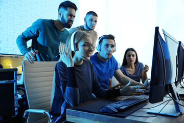 Young people playing video games on computers indoors. Esports tournament
