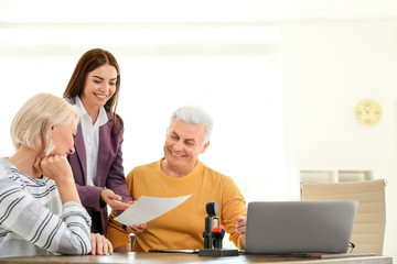 Female notary working with mature couple in office