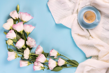 Fototapeta na wymiar Having a cup of coffee , flowers eustoma on blanket on a blue background, flat lay copy space. Holiday concept