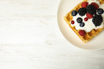 Delicious waffle with fresh berries served on white wooden table, top view. Space for text