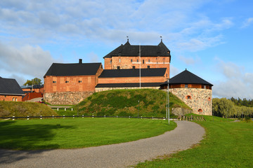Fototapeta na wymiar Medieval fortress on coast of picturesque lake Vanajavesi in Linnanpuisto park, Hameenlinna, Finland