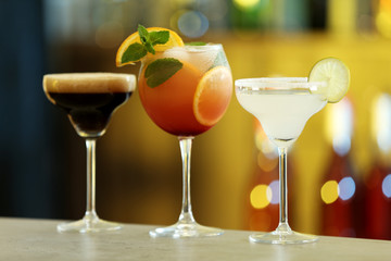 Row of different fresh alcoholic cocktails on bar counter