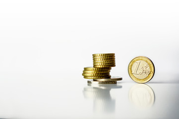One euro coin and stack of coins with reflection white backgroun