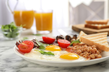 Fototapeta na wymiar Tasty breakfast with fried eggs on white marble table, closeup