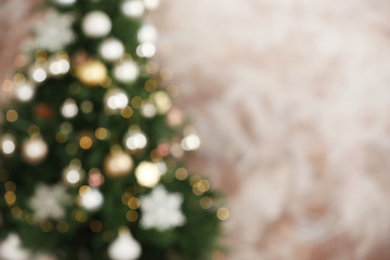 Beautiful Christmas tree with lights against brown background, blurred view. Space for text