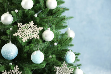 Obraz na płótnie Canvas Beautiful Christmas tree with decor against light blue background. Space for text