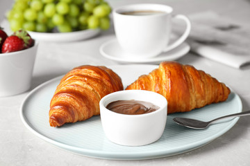 Delicious breakfast with croissants and chocolate served on light table