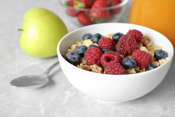 Healthy breakfast with granola and berries on light grey marble table, closeup
