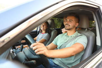 Happy family traveling by car on summer day