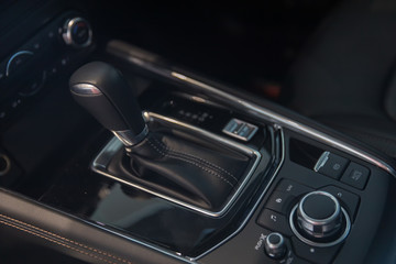 Obraz na płótnie Canvas automatic gear stick and dial gear shift control inside the car. interior automobile design. vehicle movement control concept. How to preserve the wear and tear of the motor car concept.