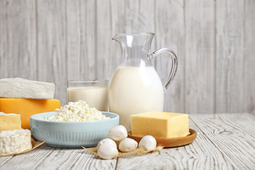Different delicious dairy products on white wooden table