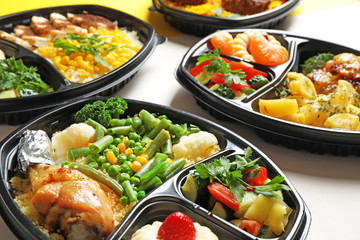 Lunchboxes with different meals on white table, closeup. Healthy food delivery