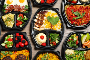 Lunchboxes with different meals on table, flat lay. Healthy food delivery