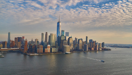 Aerial view of lower Manhattan financial district with modern architecture office buildings shot from helicopter at golden hour              