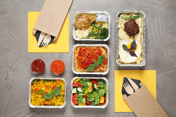 Lunchboxes on grey table, flat lay. Healthy food delivery