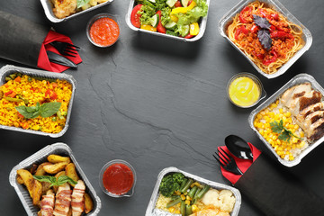 Frame made of lunchboxes on grey table, flat lay with space for text. Healthy food delivery