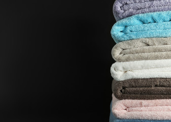 Different fresh soft terry towels on dark background. Space for text