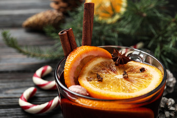 Cup of tasty mulled wine on black wooden table, closeup