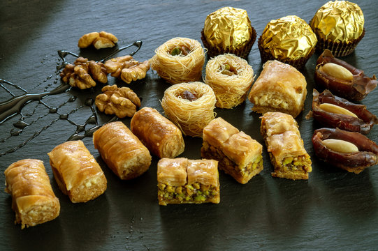different type of arabian sweets background baklava borma nest ush-el-bul-bul asabi dates and chocolate