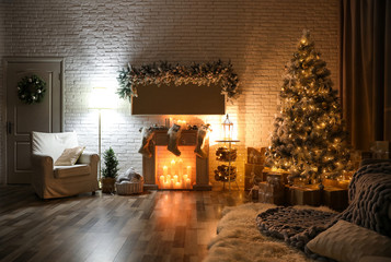 Stylish interior with beautiful Christmas tree and artificial fireplace at night