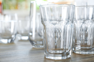 Empty glasses on wooden table against blurred background