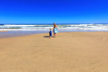 Fototapeta na wymiar Happy mother and daughter spend their holidays on the seashore.