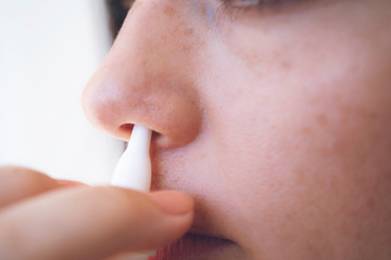 Nasal Spray. Closeup Of Beautiful Young Woman's Face With Nasal Drops. Close-up Of Female Spraying Medical Nasal Spray In Her Nose. Cold And Flu, Health Care Concept. High Resolution