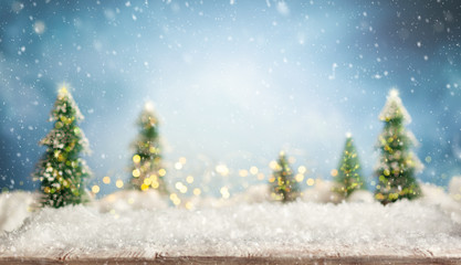 Beautiful winter background with wooden old desk, fir trees and blurred blue sky. Winter, New Year...