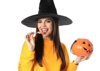 Beautiful woman wearing witch costume with Jack O'Lantern candy container for Halloween party on white background