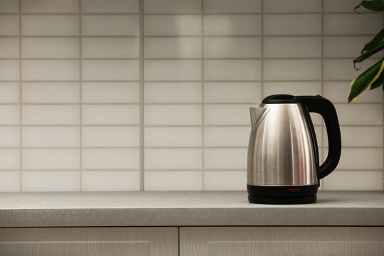 Modern Electric Kettle On Grey Kitchen Counter. Space For Text