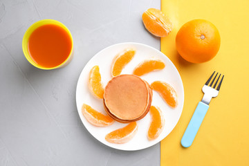 Tasty pancakes served with orange and juice on grey table, flat lay. Creative idea for kids breakfast