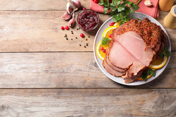 Delicious homemade ham on wooden  table, space for text. Festive dinner