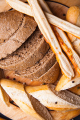 Sliced slices of black fresh rye bread on a round plate