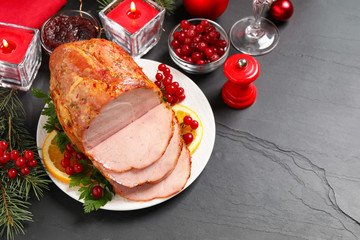 Delicious Christmas ham served with garnish on dark table, above view