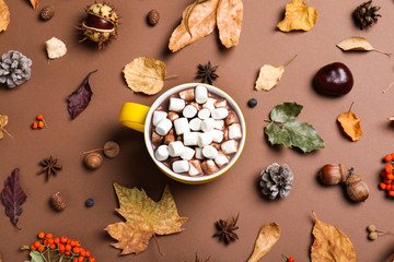 Flat lay composition with cup of hot drink on brown background. Cozy autumn atmosphere