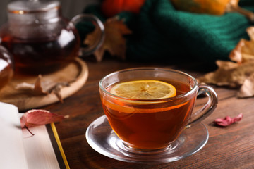 Cup of hot drink and book on wooden table. Cozy autumn atmosphere